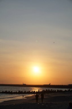 Kelan Beach, Bali 'ye gelen ziyaretçilerin silueti, öğleden sonra gün batımını bekliyor.