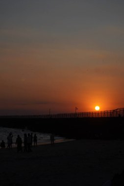 Kelan Beach, Bali 'ye gelen ziyaretçilerin silueti, öğleden sonra gün batımını bekliyor.