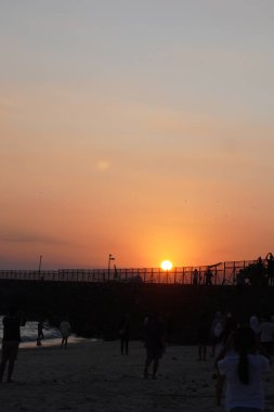 Kelan Beach, Bali 'ye gelen ziyaretçilerin silueti, öğleden sonra gün batımını bekliyor.
