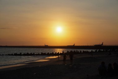 Kelan Beach, Bali 'ye gelen ziyaretçilerin silueti, öğleden sonra gün batımını bekliyor.