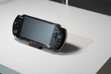 A black handheld game console from Sony called PSP on a white table clipart