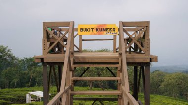 The bridge on the Bukit Kuneer which is made of wood and a photo spot for visitors at Wonosari Malang tea garden clipart