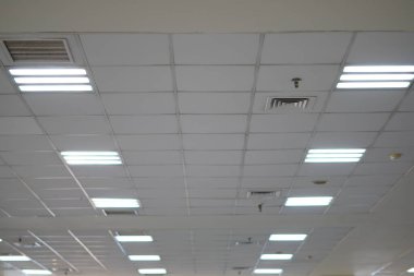 Alışveriş merkezinin tavanındaki beyaz ışıklar binayı aydınlatıyor.