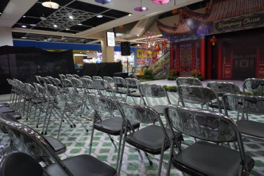 Bir alışveriş merkezinde boş bir Çin Yeni Yılı etkinliğinde siyah ve gümüş katlanan sandalyeler.