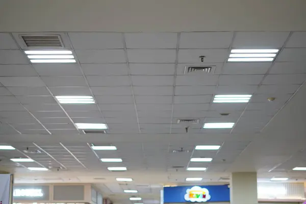 stock image The white box lights on the ceiling of a mall illuminate the building