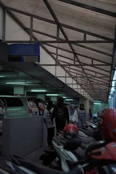 stock image Motorbike parking in a mall with visitors walking past