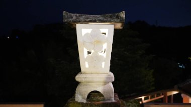 Garden lights made of white stone with a traditional design that are lit at night clipart