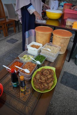 Soto ayam, fasulye filizi, patates keki, kereviz, kızarmış soğan, limon, acı sos, kraker ve soya sosundan oluşur.