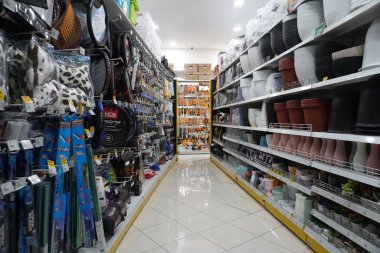 Sağda farklı şekillerde saksılar ve solda da bir mağazada araç gereçleri bulunan raflar.