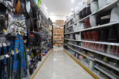 Sağda farklı şekillerde saksılar ve solda da bir mağazada araç gereçleri bulunan raflar.