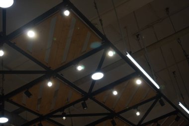 Round lights attached to the ceiling made of iron and wood in a mall clipart