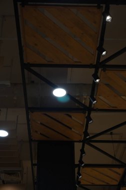 Round lights attached to the ceiling made of iron and wood in a mall clipart