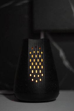 Siyah arkaplanda turuncu ışıkla aydınlatılan bir dağıtıcı