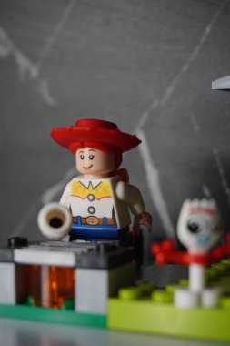 Lego figürü Jessie siyah arka planda marşmelov kızartıyor