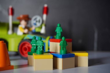 Woody ve RC arkaplanlı renkli bir kutuya yerleştirilmiş yeşil lego minyatür ordu figürü.
