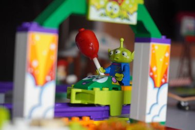 Oyuncak bir öykü filminden bir uzaylı figürü. Bir balon taşırken hız trenine biniyor.