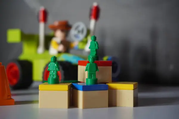 Woody ve RC arkaplanlı renkli bir kutuya yerleştirilmiş yeşil lego minyatür ordu figürü.