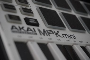 The keyboard-shaped midi controller from the black and white Akai MPK Mini is used to produce digital music clipart