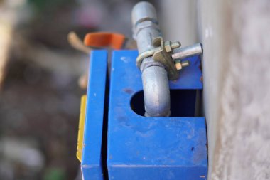 A small pipe leading into a water flow control box in a building. clipart