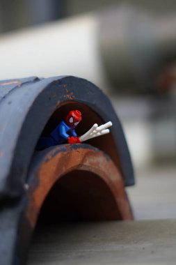 Lego minyatür Örümcek Adam arka planı bulanık bir tünelin altında sürünüyor.