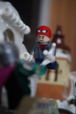 Yarı açık maskeli Peter Parker (Örümcek Adam) köprüde Mysterio ile dövüşüyor.
