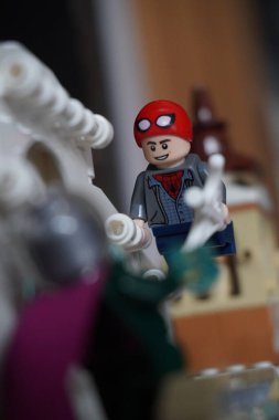 Yarı açık maskeli Peter Parker (Örümcek Adam) köprüde Mysterio ile dövüşüyor.