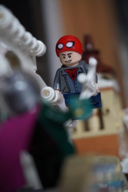 Yarı açık maskeli Peter Parker (Örümcek Adam) köprüde Mysterio ile dövüşüyor.