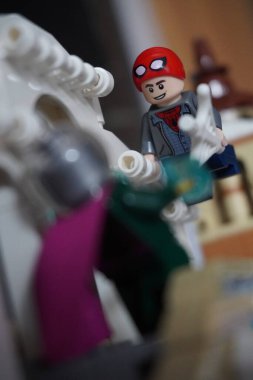 Yarı açık maskeli Peter Parker (Örümcek Adam) köprüde Mysterio ile dövüşüyor.