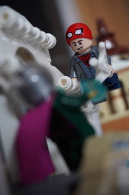 Yarı açık maskeli Peter Parker (Örümcek Adam) köprüde Mysterio ile dövüşüyor.