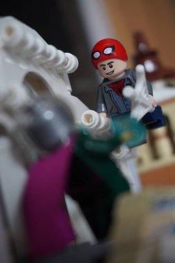 Yarı açık maskeli Peter Parker (Örümcek Adam) köprüde Mysterio ile dövüşüyor.