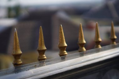 Bariyer süslemesi, keskin kenarları ve bulanık arkaplanı olan altın bir üçgen şeklinde.