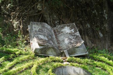 Gün boyunca Pujon Taman Kemesraan, Batu, Malang 'da yeşil bahçelerle çevrili büyük kitap şeklinde bir heykel.