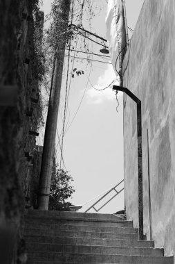 A street with stairs for pedestrians that is quiet during the day in black and white clipart