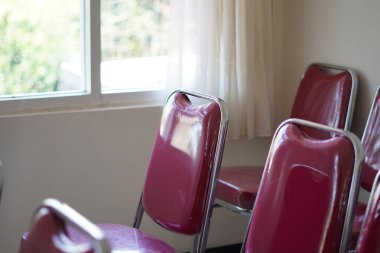 Gün boyunca kırmızı sandalyeler bir odada dizilmiş.