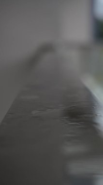 Yağmuru yansıtan balkondaki tırabzanlar.