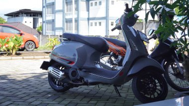 Gri Vespa restorana park ediyor.