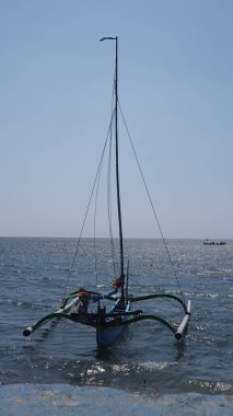 Gündüz vakti Pasir Putih Situbondo sahilinde dinlenen geleneksel bir tekne.