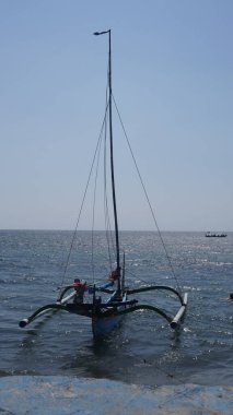 Gündüz vakti Pasir Putih Situbondo sahilinde dinlenen geleneksel bir tekne.