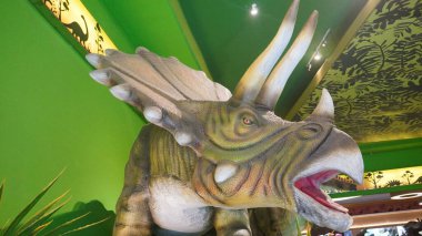 Dino Park Jatim Park 3 'ün girişinde ağzı açık Triceratops heykeli.