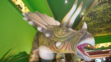 Dino Park Jatim Park 3 'ün girişinde ağzı açık Triceratops heykeli.