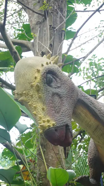 stock image A bald-headed dinosaur statue looking down