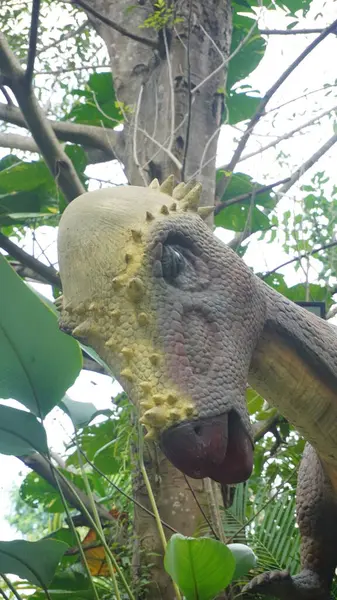 stock image A bald-headed dinosaur statue looking down