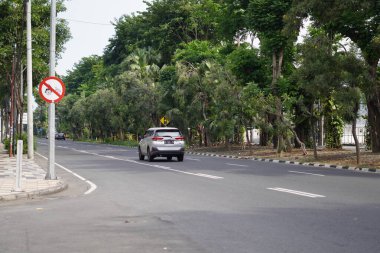 Yol kenarında ağaçlar ve birkaç sürücünün olduğu sessiz bir otoyol.