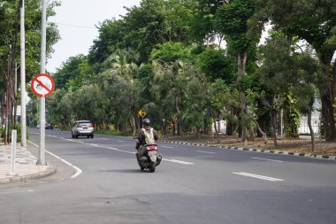 Yol kenarında ağaçlar ve birkaç sürücünün olduğu sessiz bir otoyol.