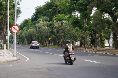 Yol kenarında ağaçlar ve birkaç sürücünün olduğu sessiz bir otoyol.