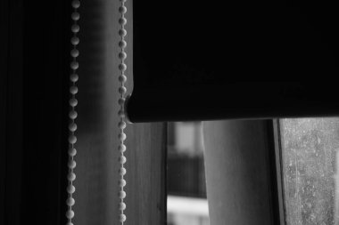 Pencere siyah beyaz perdelerle kaplanmış paten perdeleriyle açık.