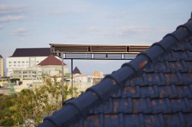 Rooftop of a house with a view of campus buildings in the afternoon clipart