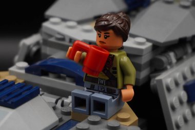 Yıldız Savaşları 'ndan kalma Lego figürü elinde cam olan bir uzay gemisinin kanadında oturuyor.