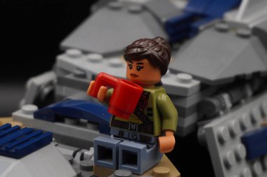 Yıldız Savaşları 'ndan kalma Lego figürü elinde cam olan bir uzay gemisinin kanadında oturuyor.