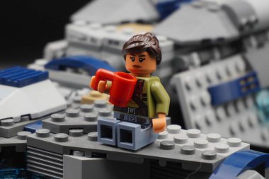 Yıldız Savaşları 'ndan kalma Lego figürü elinde cam olan bir uzay gemisinin kanadında oturuyor.